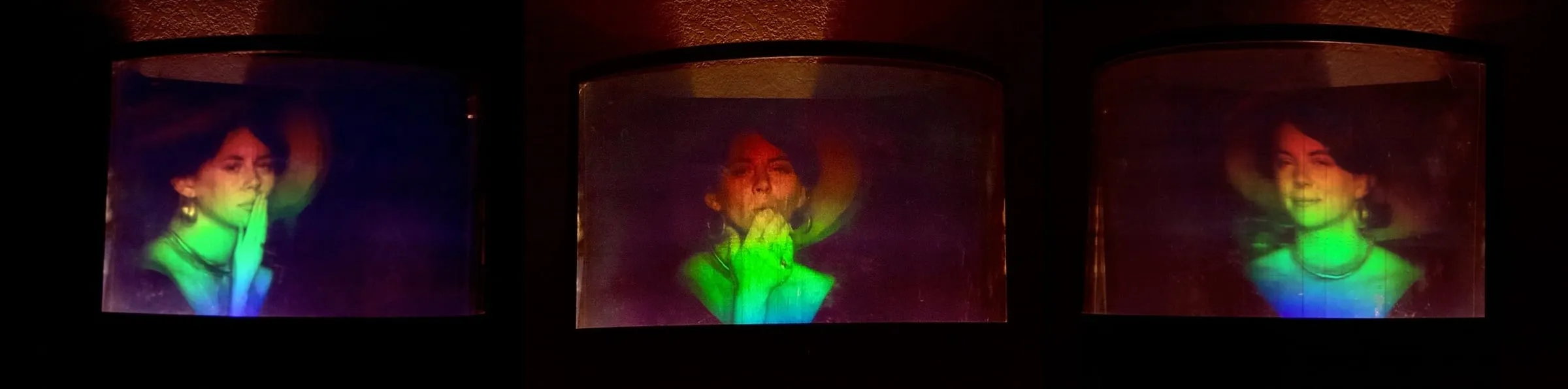 The unbleached "Kiss I" multiplex hologram shown from three viewing angles — a woman with her hands raised near her face, the image shifting in color and perspective across the three views.