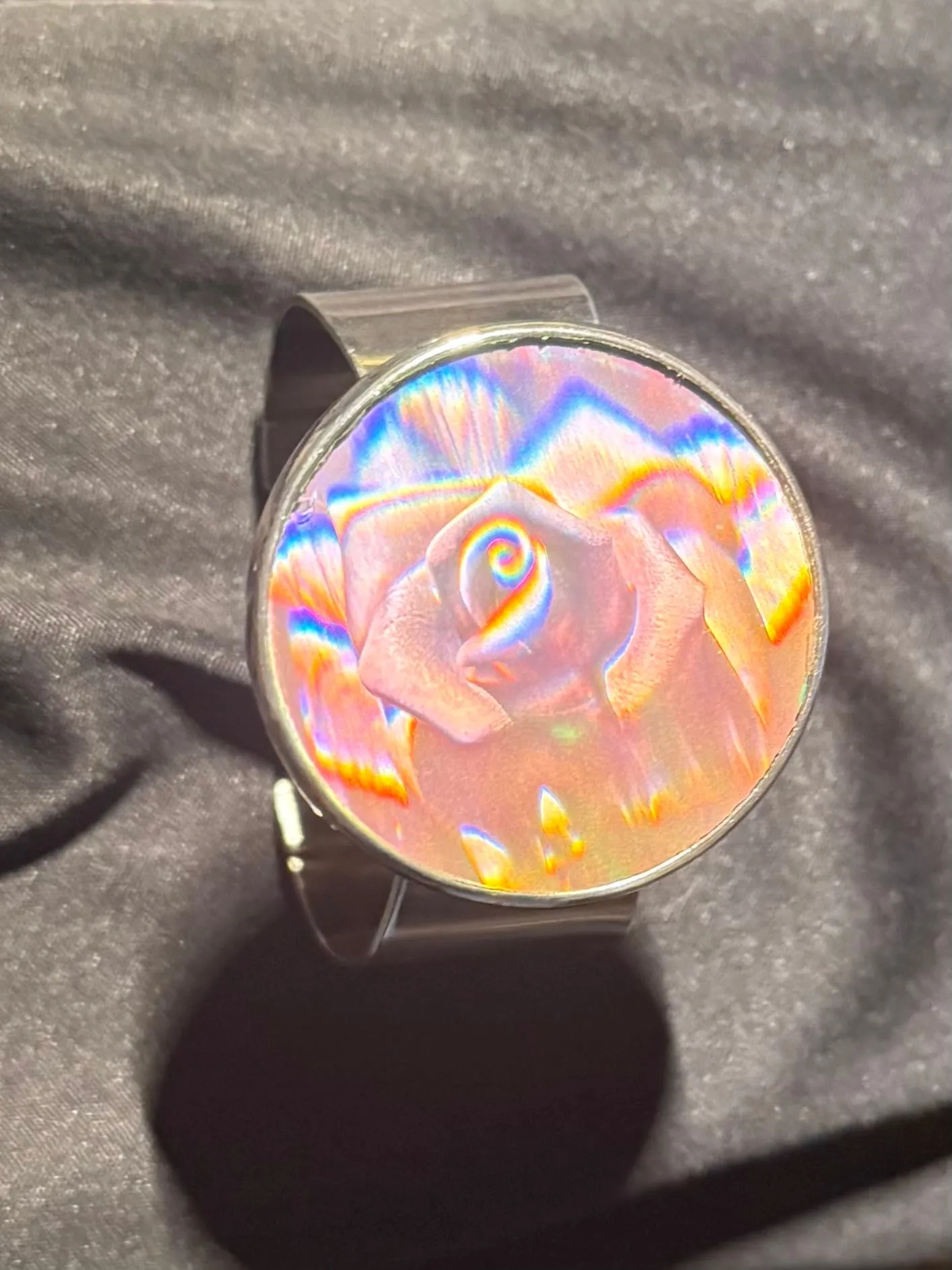 A silver cuff bracelet set with an embedded hologram.