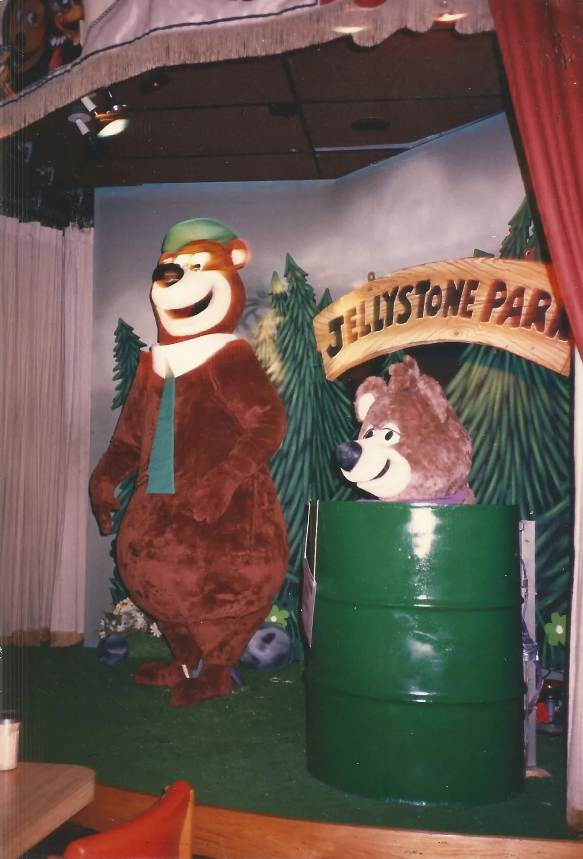 The Yogi Bear animatronic show at ShowBiz Pizza Place — Yogi in a green hat and tie beside Boo-Boo, on the Jellystone Park stage.